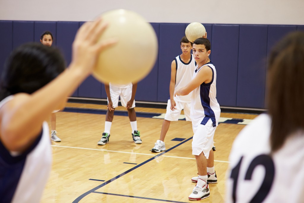 High School Students Playing Dodge Ball In Gym